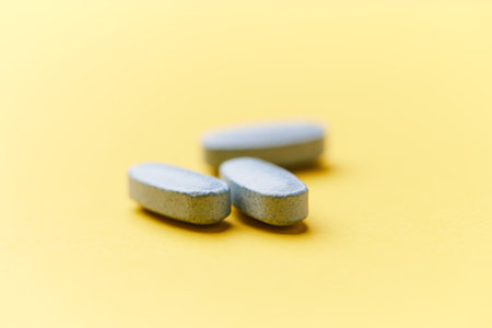 Pills on yellow background. Focus on foreground, soft bokeh.の写真素材