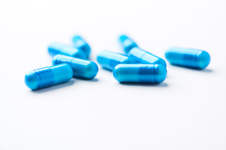 Blue pills on white background. Focus on foreground, soft bokeh.の写真素材