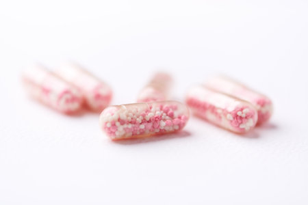 Close up of pink pills on white background. Focus on foreground.の写真素材