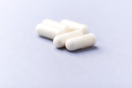 White pills on a gray background. Focus on foreground, soft bokeh.