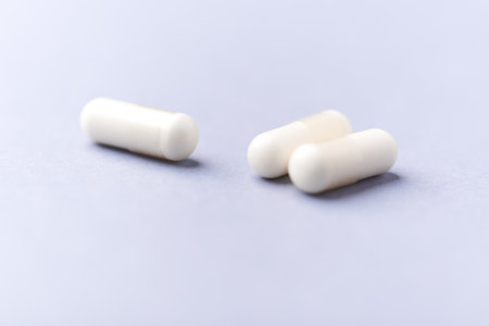 White pills on a blue background. Focus on foreground, soft bokeh.の写真素材
