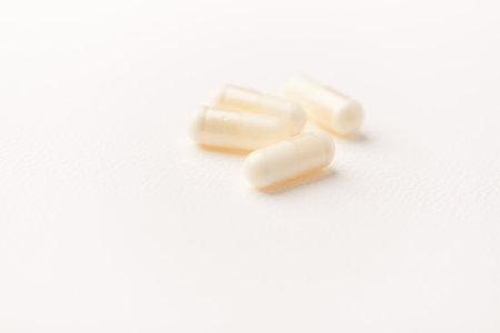 Close up of white pills on white background. Focus on foreground, soft bokeh.