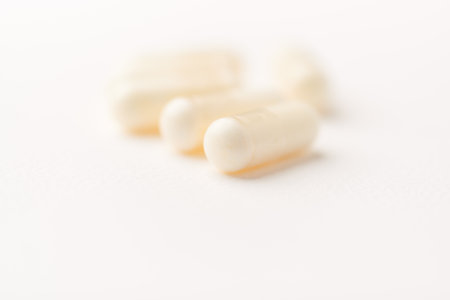 Capsules of white pills on a white background close-up