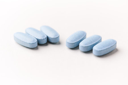 Blue pills on white background. Focus on foreground, soft bokeh.の写真素材