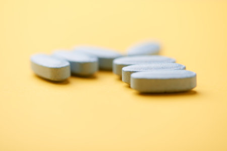 Pills on a yellow background. Focus on foreground, soft bokeh.