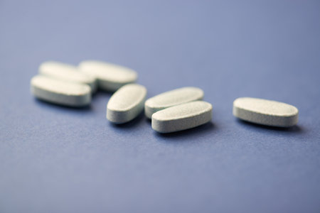Pills on a blue background. Focus on foreground, soft bokeh.