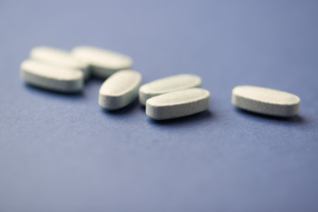 Pills on a blue background. Focus on foreground, soft bokeh.