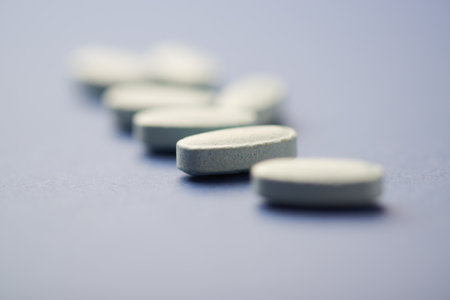 Pills on a blue background. Focus on foreground, soft bokeh.
