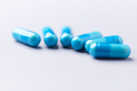 Blue pills on a white background. Close up. Focus on foreground.