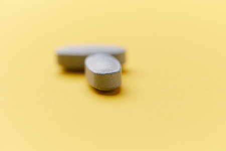 Pills on a yellow background. Focus on foreground, shallow depth of field.の写真素材