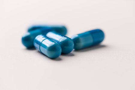 Blue pills on white background. Focus on foreground, soft bokeh.の写真素材