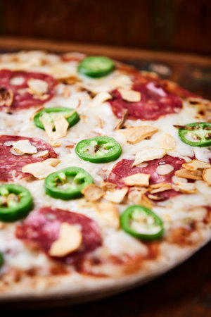 Pizza with salami, cheese, jalapeno peppersの写真素材