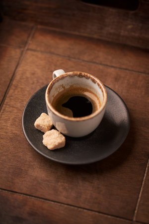 Cup of coffee with sugar cubes on wooden background. Toned.の写真素材
