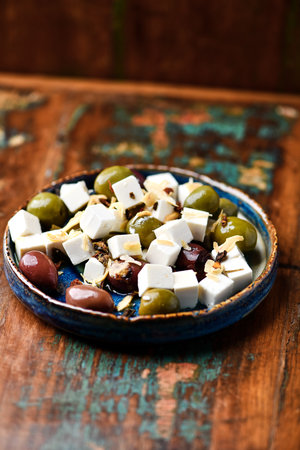 Greek salad with feta cheese, olives and nuts on rustic wooden backgroundの写真素材