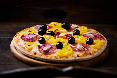 Pizza with salami, olives and cheese on wooden background
