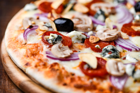 Pizza with mozzarella, mushrooms and olives on wooden backgroundの写真素材