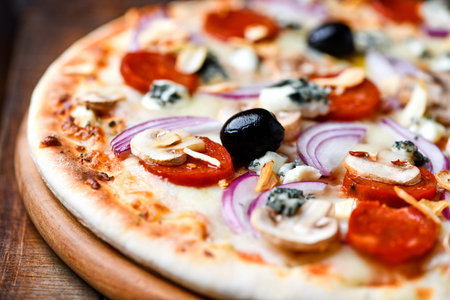pizza with mozzarella, tomato and olives on wooden backgroundの写真素材