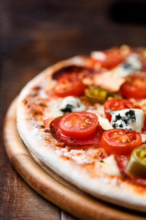 Pizza with mozzarella and tomatoes on wooden backgroundの写真素材