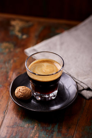 Coffee in a glass cup on a wooden table, selective focusの写真素材