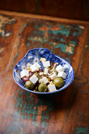 Greek salad with feta cheese and olives on a blue plateの写真素材