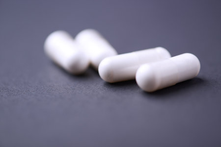 White pills on a black background. Focus on foreground, soft bokeh.の写真素材