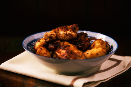 Fried chicken breast with potatoes. Rustic wooden background. Soft focus.の写真素材
