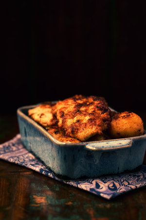 Fried chicken breast with potatoes. Rustic wooden background. Soft focus.の写真素材