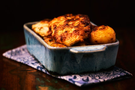Fried chicken breast with potatoes. Rustic wooden background. Soft focus.の写真素材