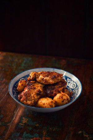 Fried chicken breast with potatoes. Rustic wooden background. Soft focus.の写真素材
