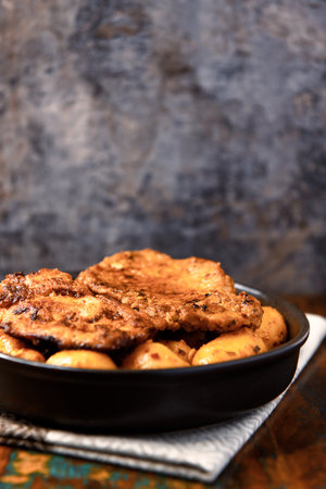 Fried pork chops with potatoes in a frying pan. Selective focus.の写真素材