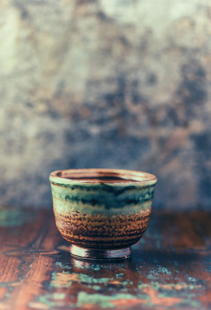 Vintage ceramic cup on rustic wooden table.の写真素材