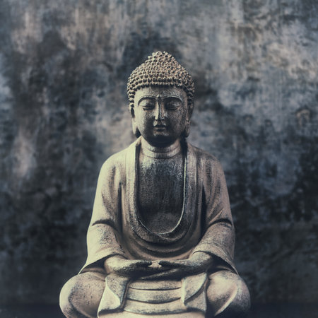 Buddha statue on grunge wall background, vintage tone.の写真素材