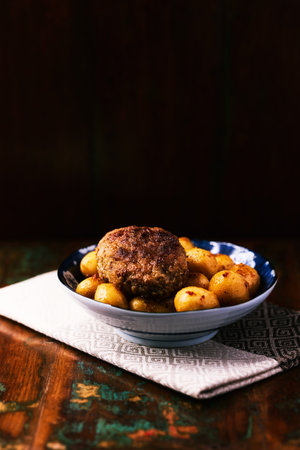 fried meatballs with potatoes on a wooden background. tinting. selective focus