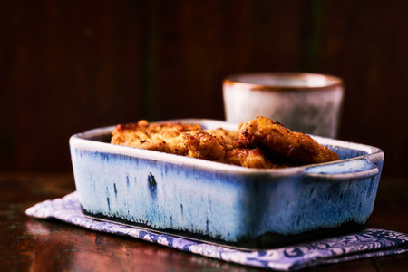 Fried chicken with potatoes in a cast-iron frying pan.