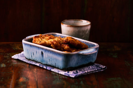 Fried chicken with potatoes in a cast-iron frying pan.の写真素材