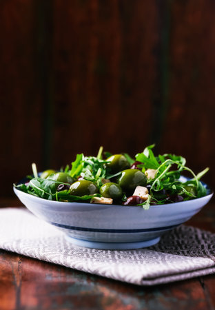 green salad with olives and arugula on a wooden backgroundの写真素材