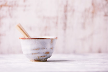 Ceramic bowl and chopsticks on white wooden background. Selective focus.の写真素材