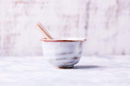 Ceramic bowl and chopsticks on a white wooden background.の写真素材
