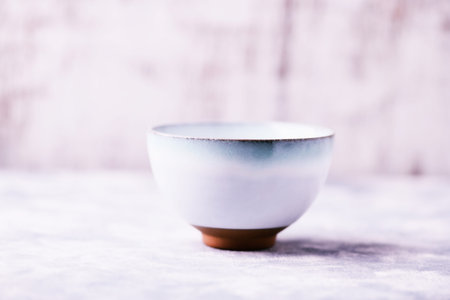 Empty ceramic bowl on a white wooden background. Selective focus.の写真素材