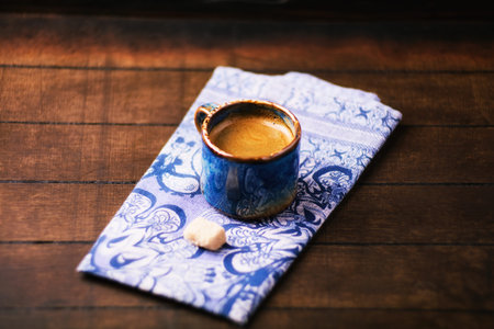 Coffee cup on a blue napkin on a wooden tableの写真素材