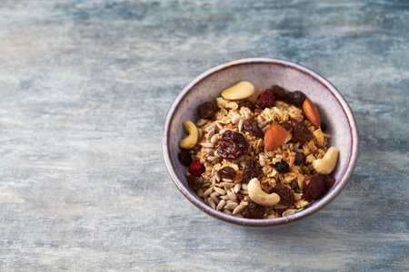 Healthy breakfast bowl with muesli, nuts and raisins.