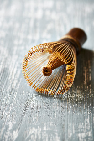 Metal whisk on a wooden background. Selective focus.