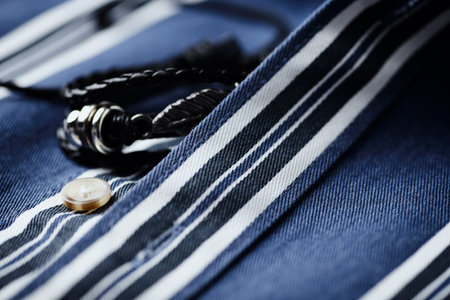 Close up of blue striped shirt with button. Shallow depth of field.