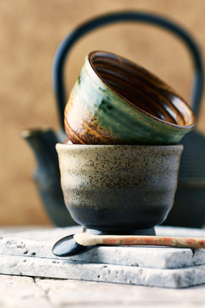Ceramic teapot and cups on wooden table. Selective focus