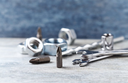 Set of metal construction tools on grey wooden table. Selective focus.