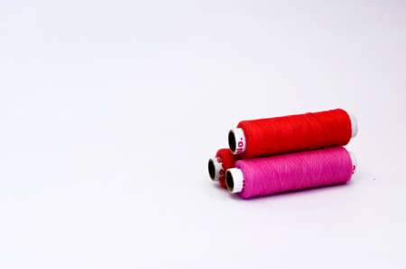 Colorful spools of thread on white background with copy space.
