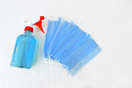 Surgical mask with hand sanitizer isolated on white