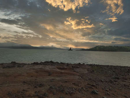dramatic sky over lake with a boatの写真素材