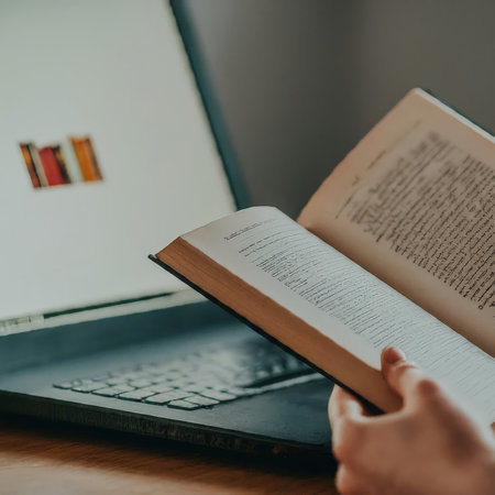 a person reading book in front of laptop.の素材