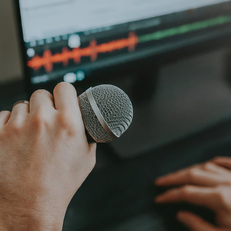 man using computer to listen music in microphone, online learning, audio education conceptの素材
